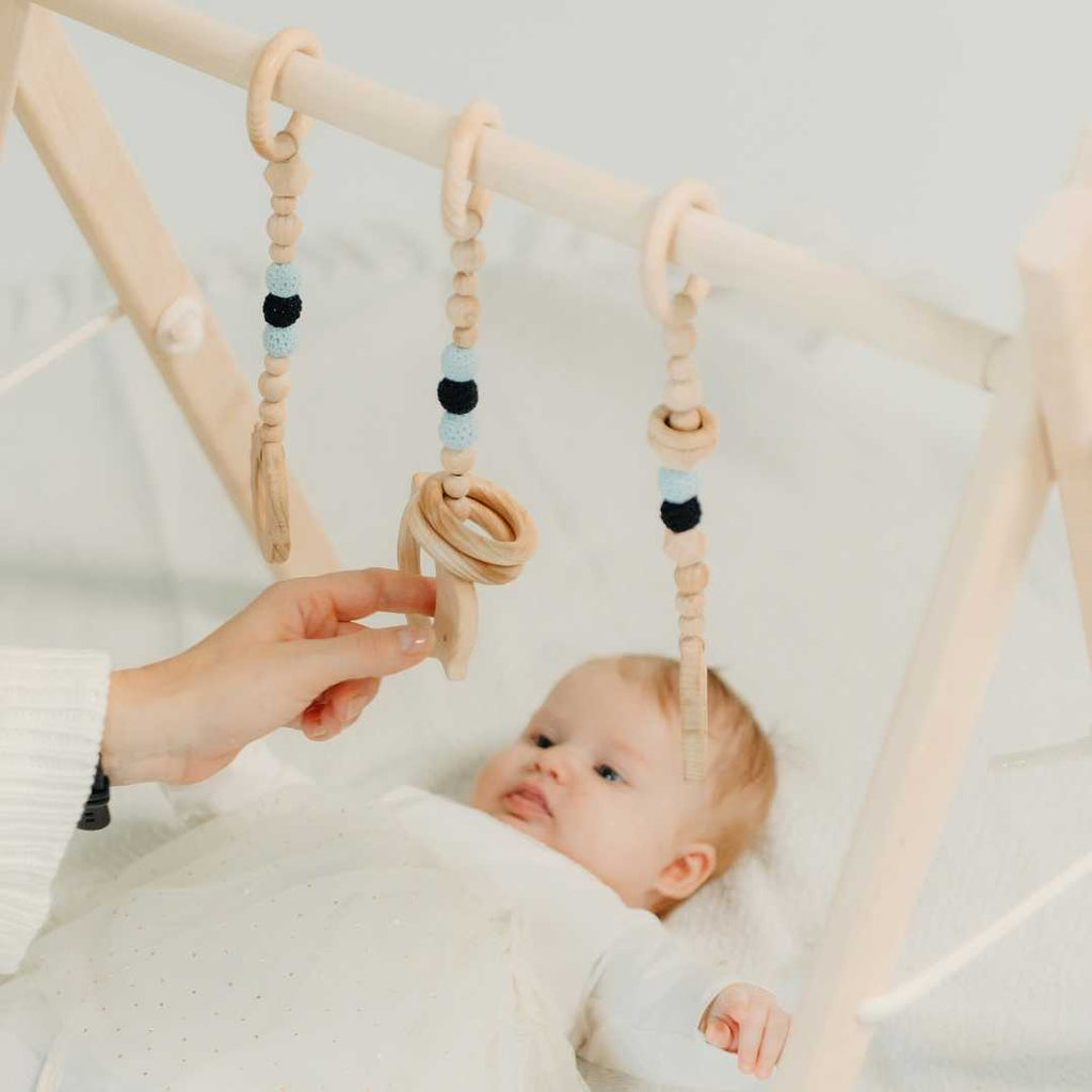Holz-Babyspielbogen mit schwarz-weißem Spielzeug